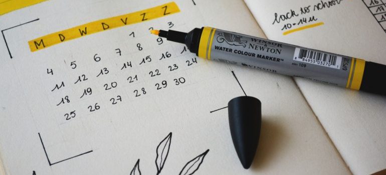 A calendar in a notebook and a marker