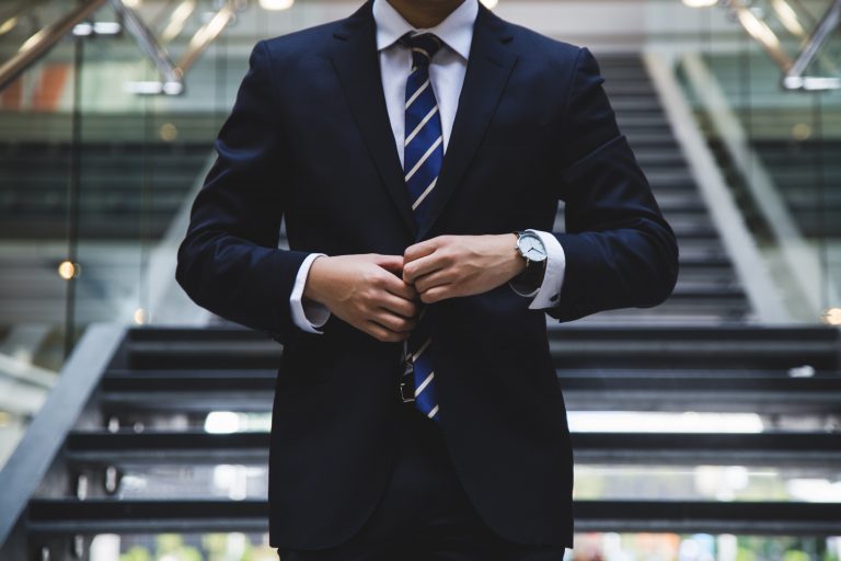 a person in a suit doing buttons