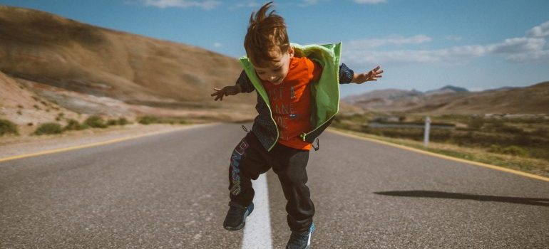 child jumping on the road