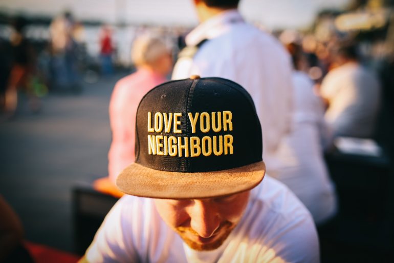 A man with a "Love your neighbor" hat. 