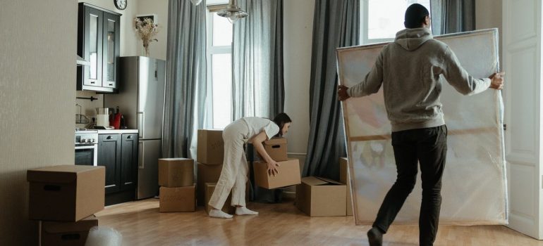 a couple moving items into the living room