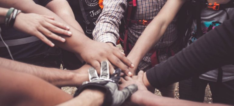 several people putting their hands together in the center