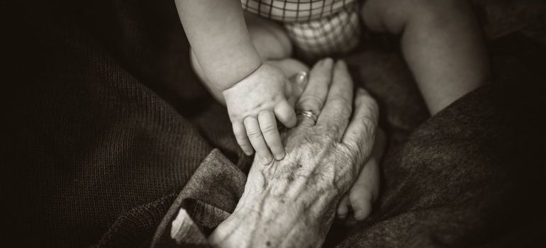 A senior women holding her grandchild's hand before the move