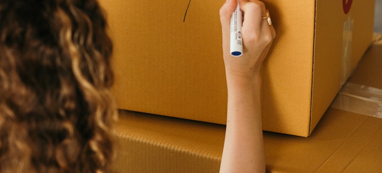 A woman labeling a box
