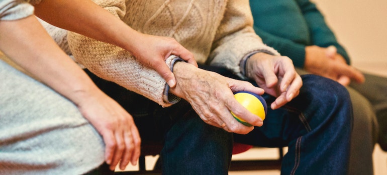 A woman holding a senior's hand