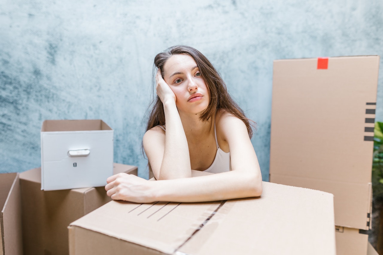 A woman thinking about how many moving boxes do you need for a successful move.