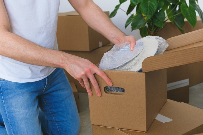 A person placing breakables in a box - pack fragile items