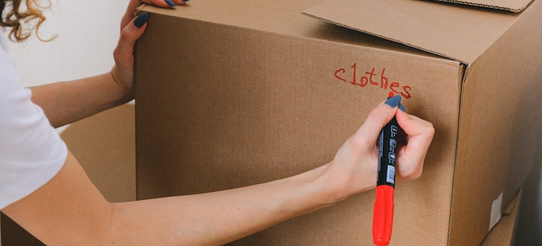 A person packing a moving box