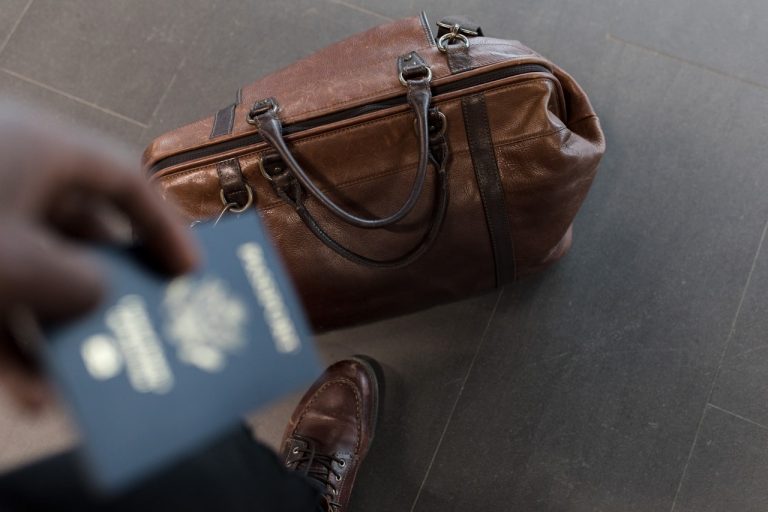 A passport and a brown leather bag