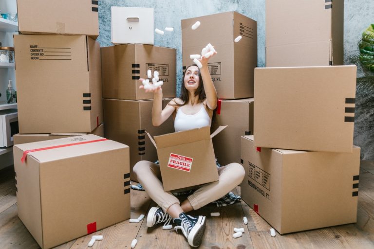 woman sitting next to cardboard boxes