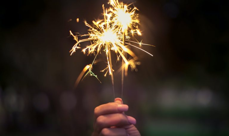 A woman hand is holding fireworks.