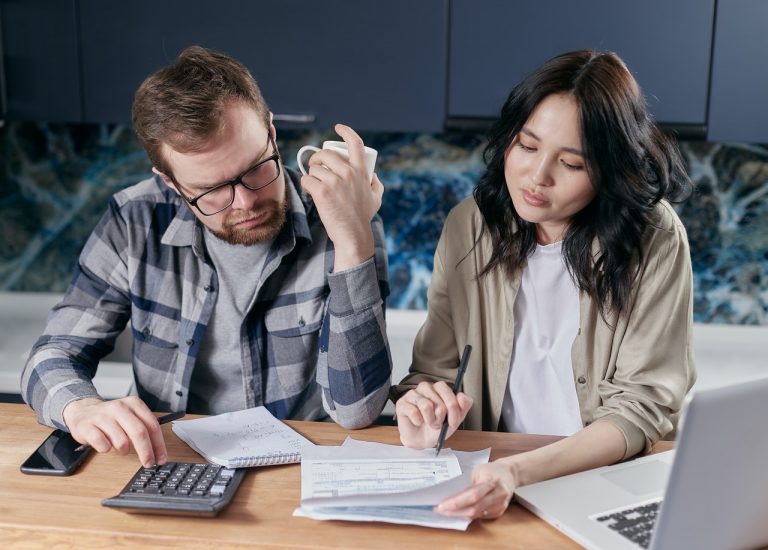 a couple consulting over finances in their living room