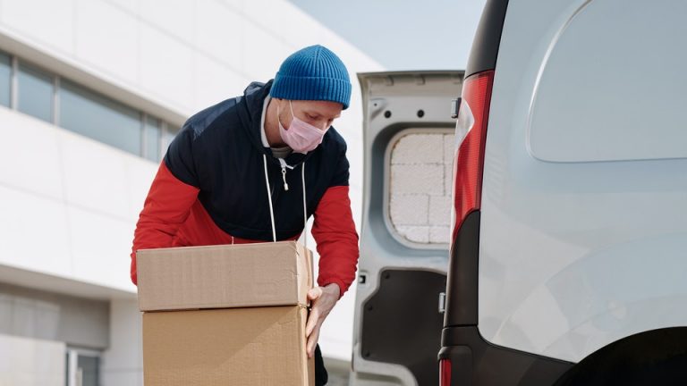 Man packing boxes while wearing a face mask