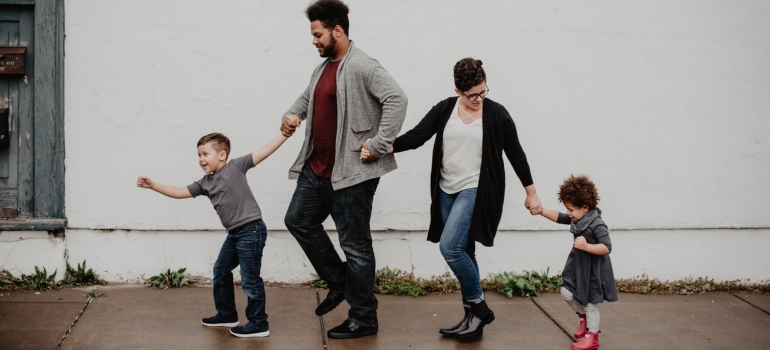  Family of four holding their hands