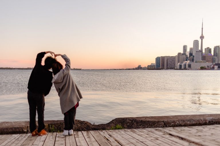 Two people holding hands while looking at Toronto skyline