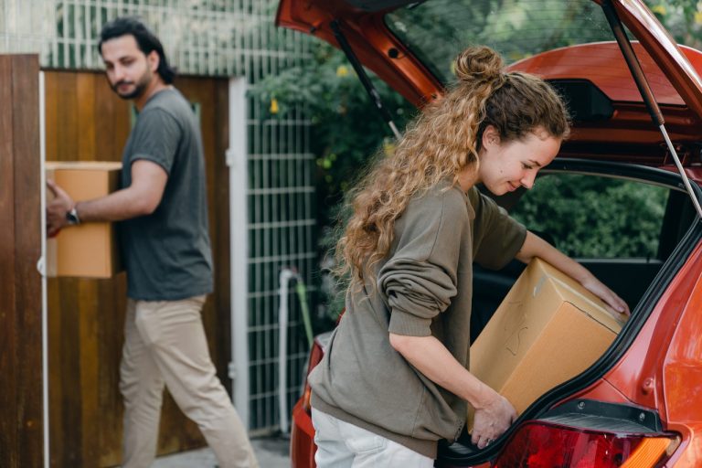 Couple unpacking car while moving to new home