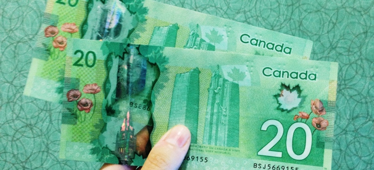 a woman holding dollars to pay for moving during summer