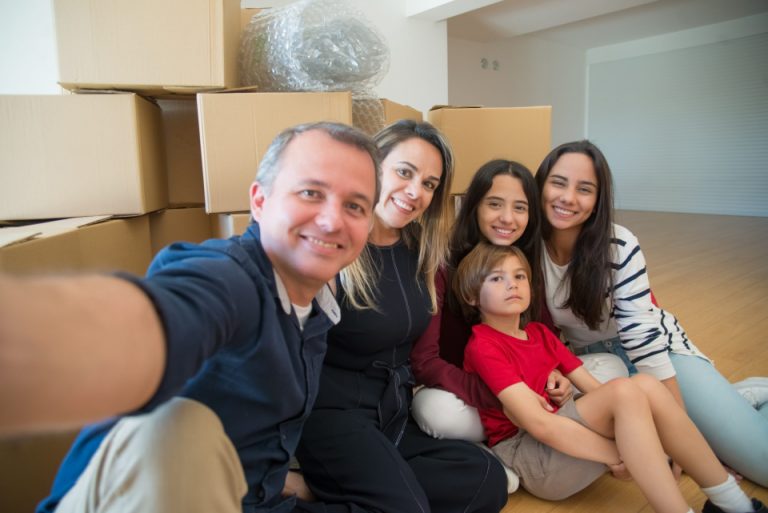 A family taking a selfie and thinking do with used moving boxes after relocating to Prescott