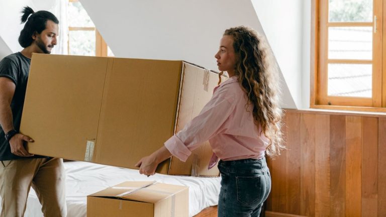 Two people carrying a box