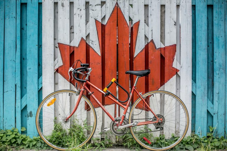 A bike next to a wall with a picture of Canada flag drawn on it