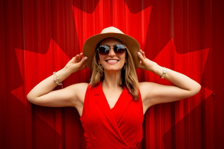 A woman posing in front of Canada flag sign