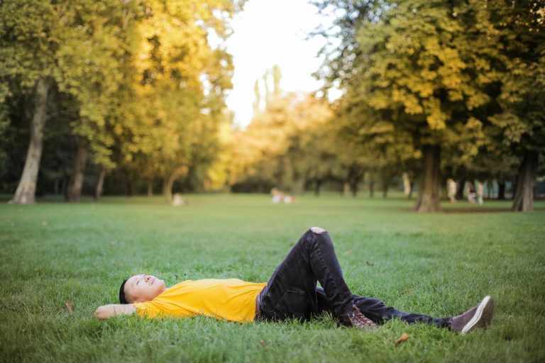 Man lying down on grass thinking
