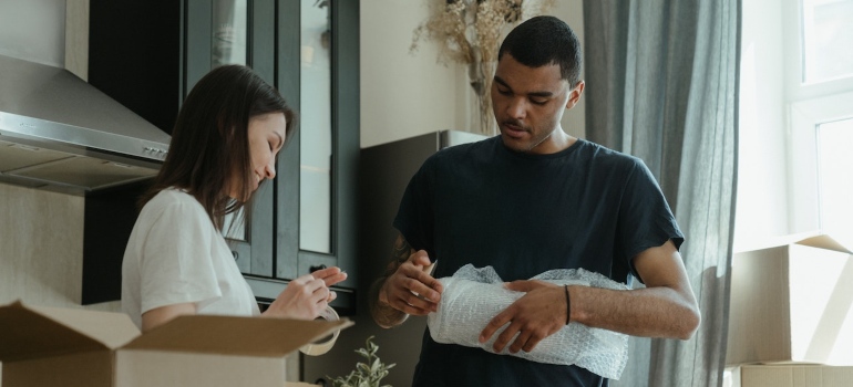 A man and woman packing for the move