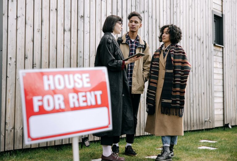 Couple talking with real estate agent in front of the house for rent