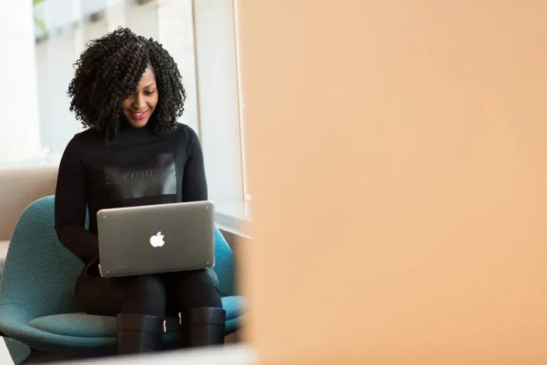 A girl typing and looking at a laptop