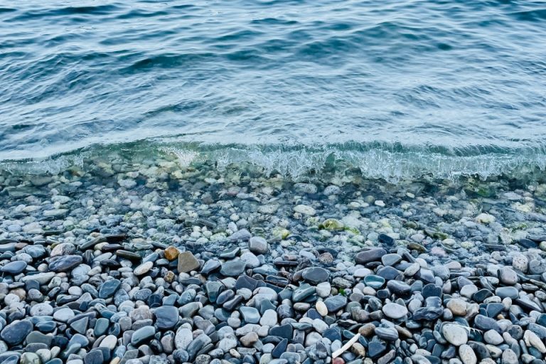 A photo of water and rocks on a beach