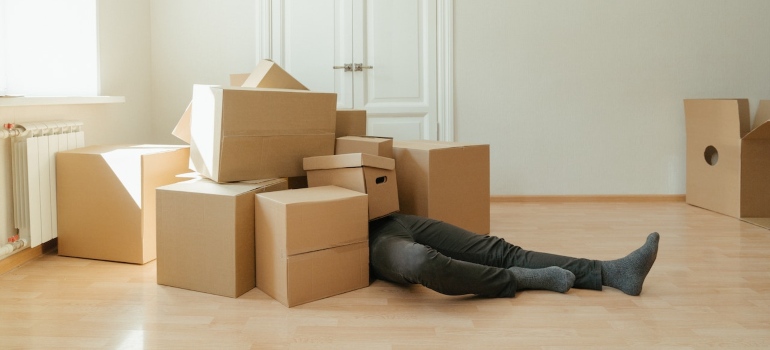 A man lying on the floor between the boxes