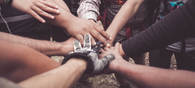 People shaking hands at team building event and talking about how to take good care of yourself while moving