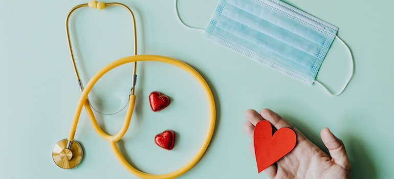 A stetoscope and a mask next to heart-shaped chocolates