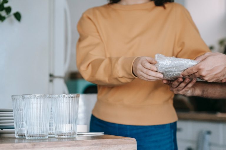A woman ready to pack glassware and dishes for a move