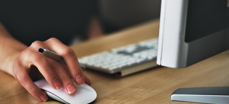A perdon using a computer mouse to search the internet and find a moving company for a stress-free move from Burlington to Bradford
