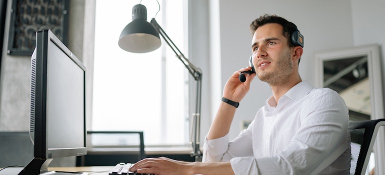 A man in an office next to a computer