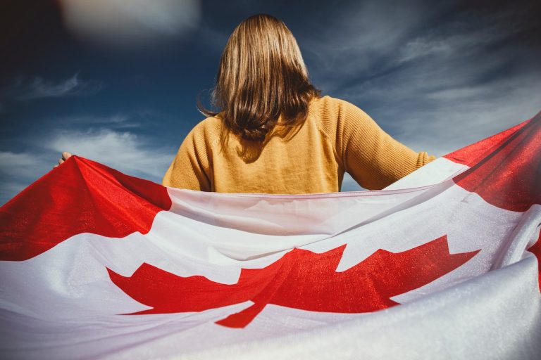 A woman holding Canada flag and thinking about peaceful Canada places