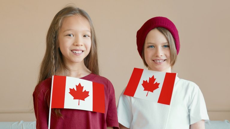 Two girls holding Canadian flags as international students moving to Canada