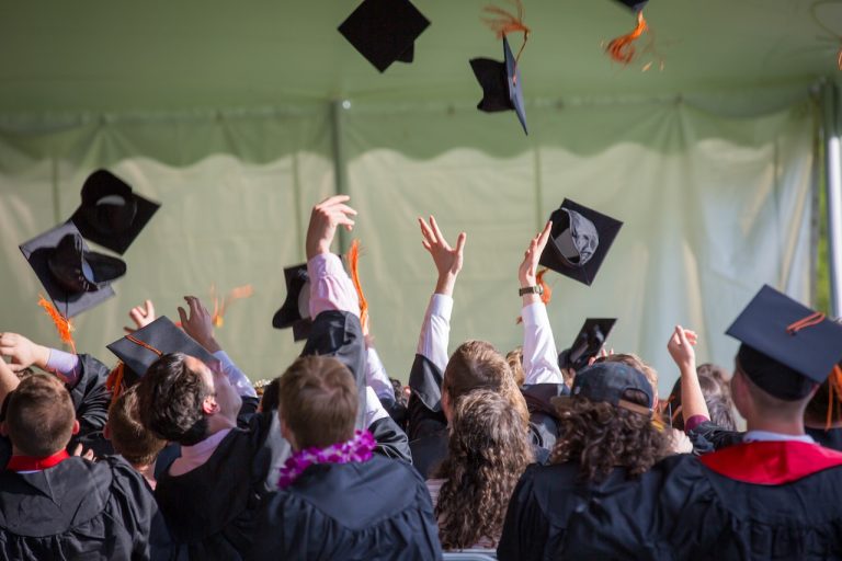 Students throwing graduating hats in the air