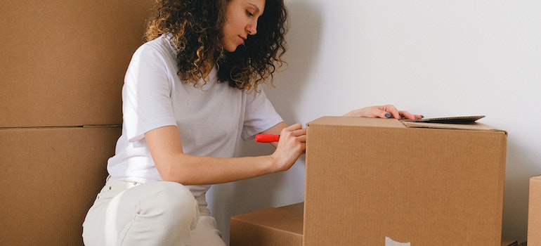 A girl labeling moving boxes