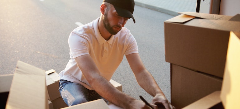 A movers surrounded y moving boxes looking for something