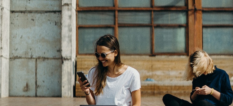 Girls using their phones to learn about things to avoid after moving to Toronto