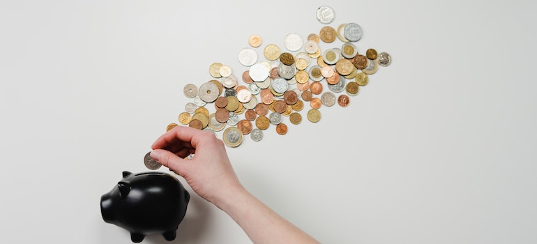 A person putting coins in a piggy bank