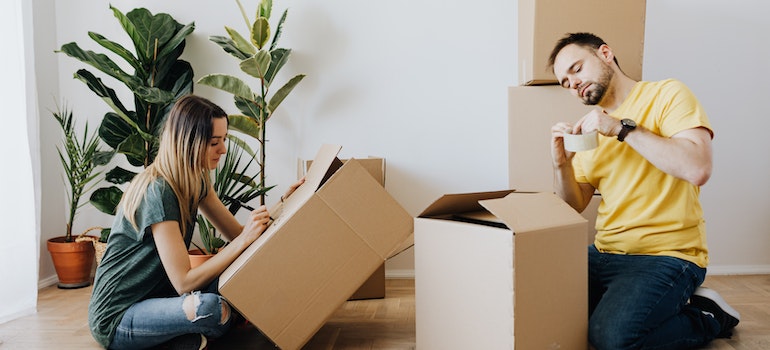 Two people packing moving boxes