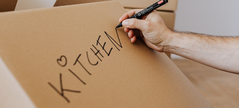 A person labeling a moving boxes