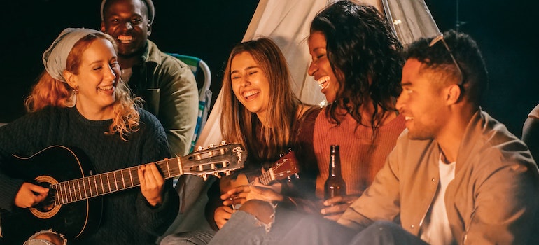 Peoples sitting, singing and playing guitar