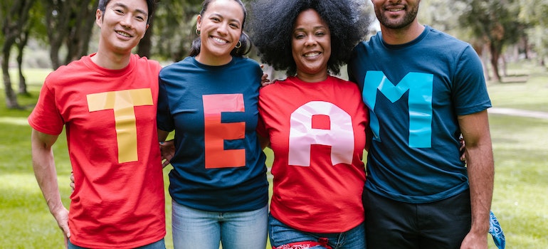 Four people with TEAM spelled from letters on their T-shirts