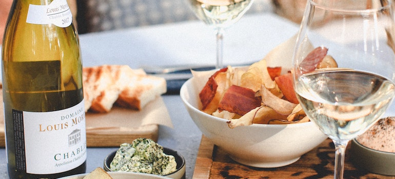 Wine glasses, a bottle and food on a table