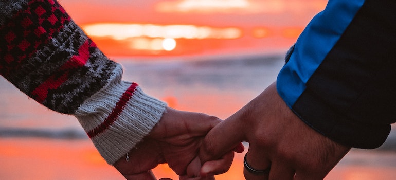 A couple holding hands in the sunset