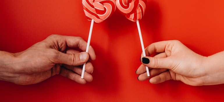 A couple with heart shaped lollipops